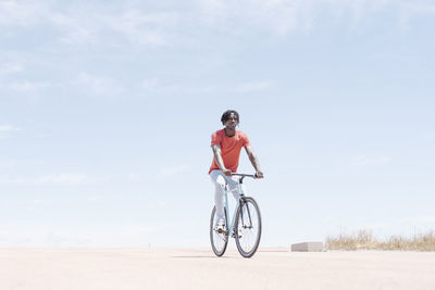 Man riding bicycle on embankment