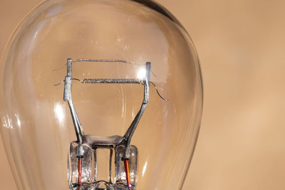 Close-up of illuminated light bulb against wall