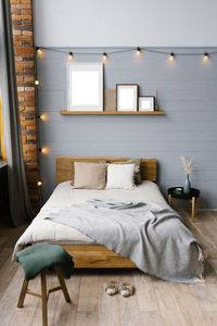 Double bed with natural natural accents on the sheets and beige pillows in the grey scandinavian