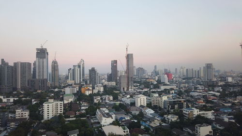 Aerial view of buildings in city against clear sky