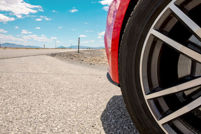 Close-up of tire of red sports car on road