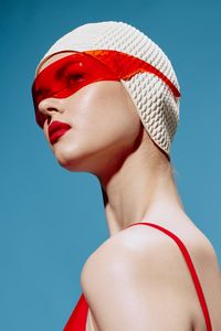 Low angle view of woman wearing mask against clear sky