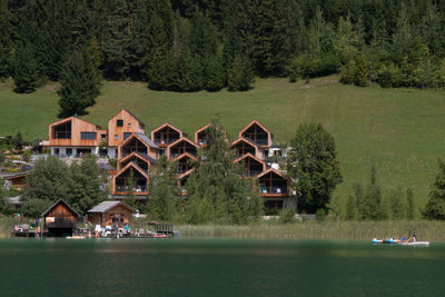 Houses by lake and trees in forest