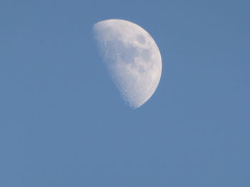 Low angle view of moon against clear blue sky