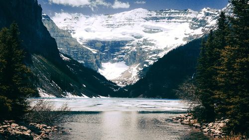 Scenic view of lake by snowcapped mountains during winter