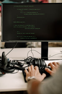 Cropped hands of entrepreneur working on computer programming at workplace