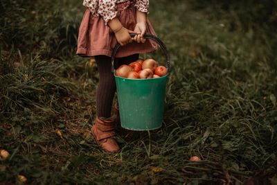 Low section of man holding fruit on field