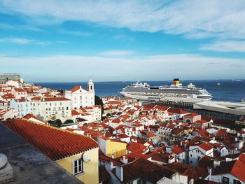 High angle view of townscape by sea against sky