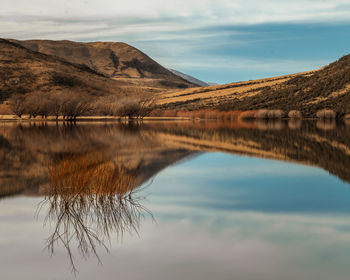 Scenic view of lake by mountain against sky