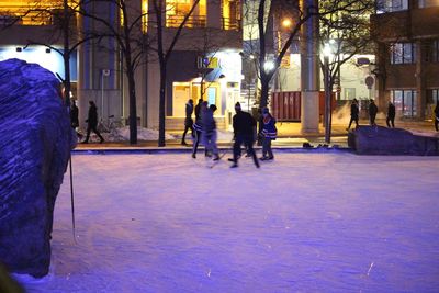 People in illuminated city during winter