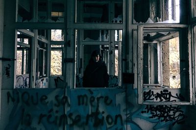 Portrait of young woman standing in abandoned building