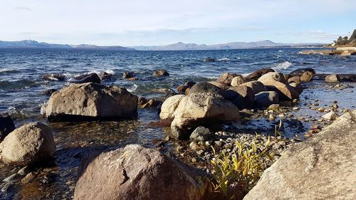 Rocks on beach against sky