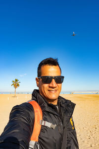 Portrait of man wearing sunglasses against clear sky