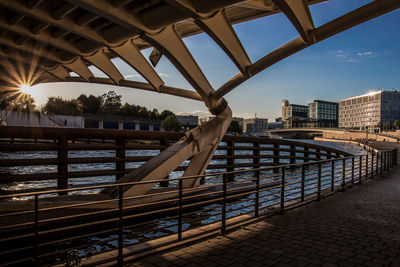 Bridge over river in city against sky