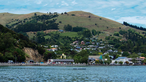 Scenic view of sea by buildings against sky