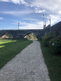 Footpath leading towards historic building against sky