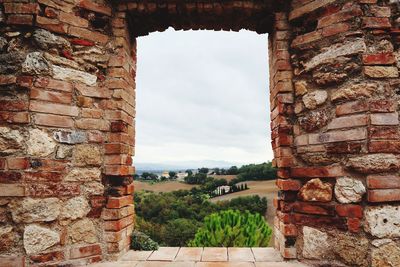Stone wall of historic building against sky