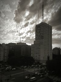 Buildings in city against cloudy sky