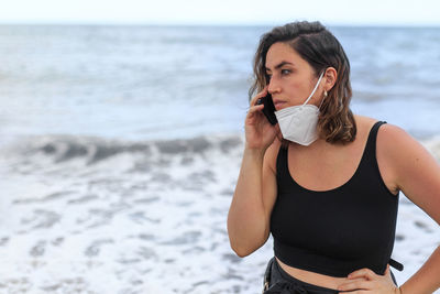 Portrait of beautiful woman standing on beach