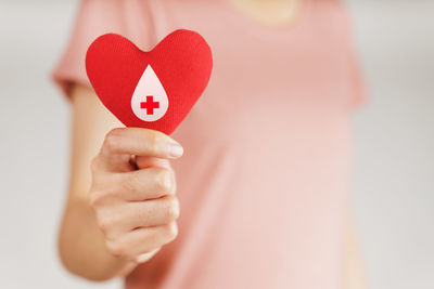 Close-up of woman holding heart shape