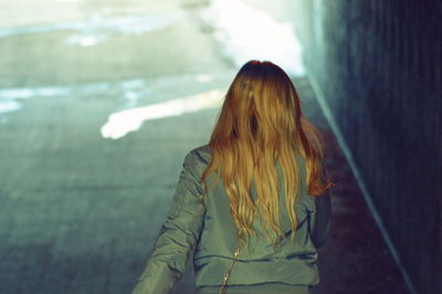 Rear view of woman walking on road