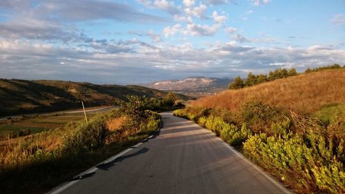 Empty road along countryside landscape