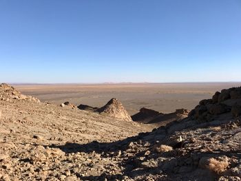Scenic view of desert against clear blue sky