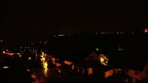 Illuminated city against sky at night