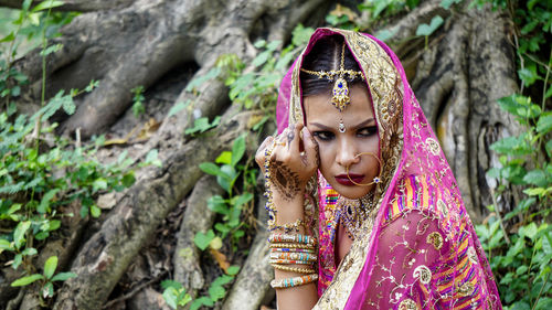 Close-up of bride wearing traditional costume in forest