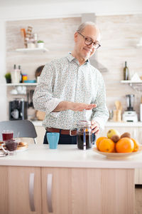 Man preparing coffee while standing at home