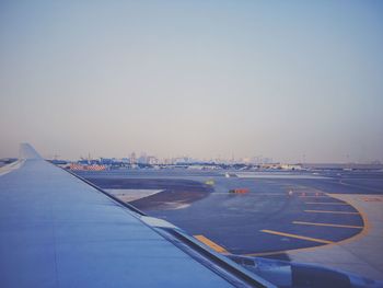 Airplane on airport runway against clear blue sky