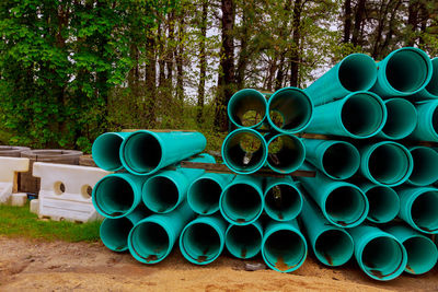 Stack of pipes against trees in forest