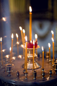 Yellow orange burning church candles in a candlestick