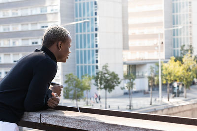 Side view of young man looking away in city