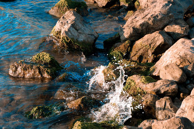 High angle view of stream flowing through rocks