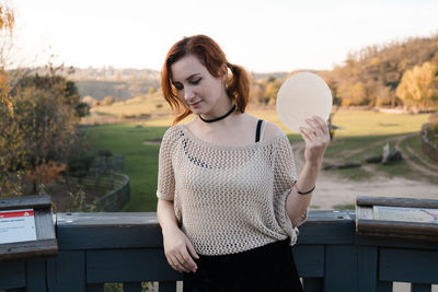 Full length of young woman standing on bench