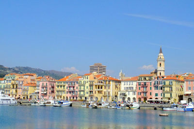 Harbor by cityscape against sky