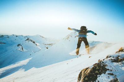 Person skiing on snowcapped mountain against sky