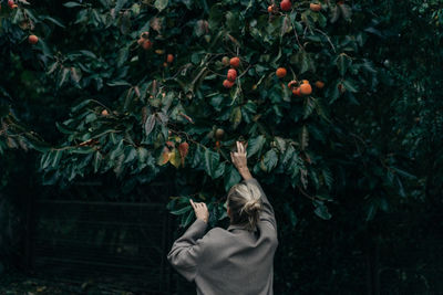 Rear view of woman standing against plants