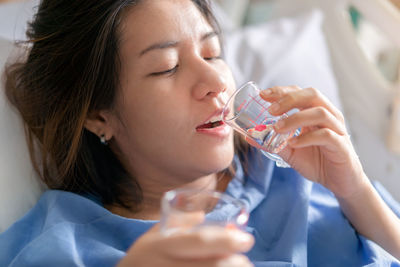 Close-up portrait of a woman drinking glass