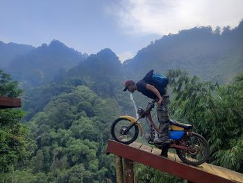 Rear view of man riding bicycle on mountain
