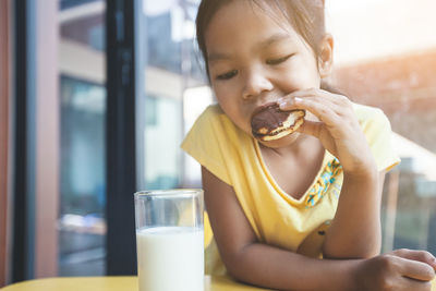 Close-up of girl eating food on table at home