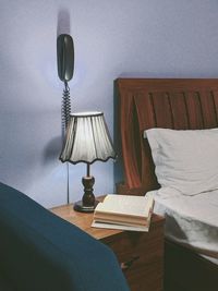 Electric lamp on bed against wall at home