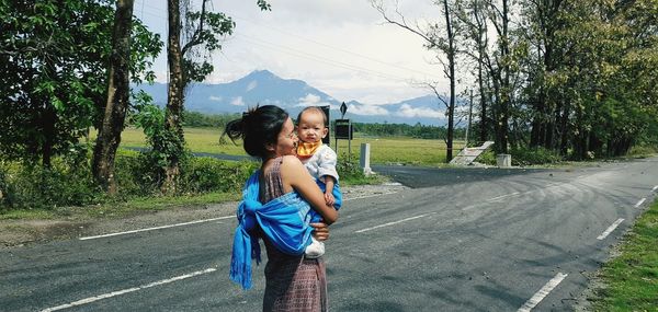 Full length of women standing on road against trees