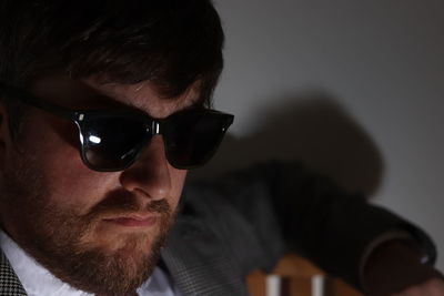 Close-up portrait of bearded man wearing sunglasses at home