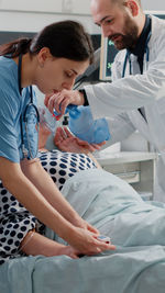 Side view of doctor examining patient at clinic