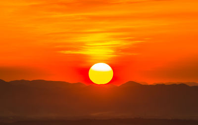 Scenic view of silhouette mountains against romantic sky at sunset