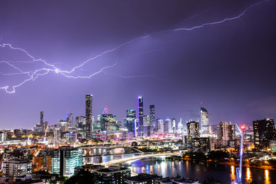 Illuminated cityscape against sky at night