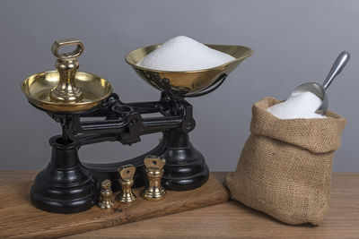 Close-up of vintage weight scale by sugar on table