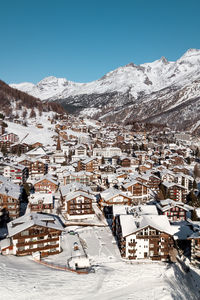 Houses on snow covered mountain against sky